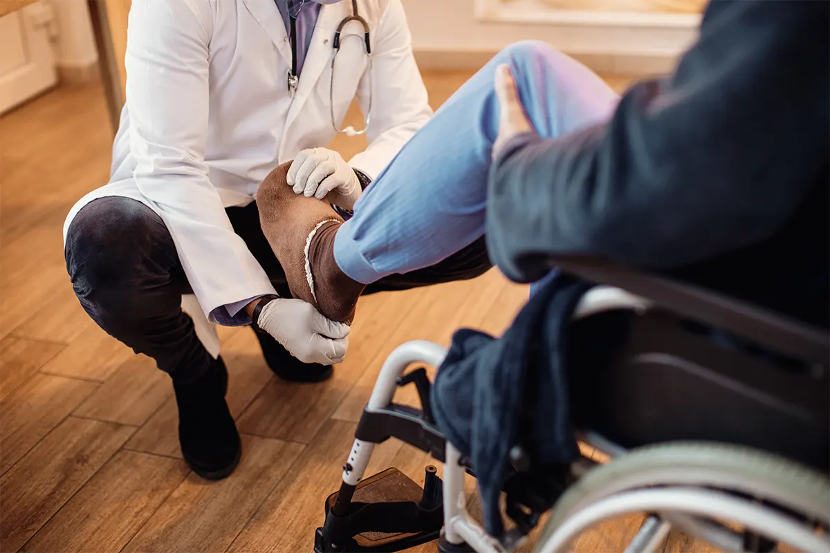 Ärztliche Untersuchung eines Patienten im Rollstuhl – Behandlung nach BG-Verordnung als Grundlage für Physiotherapie und Ergotherapie nach Arbeitsunfall. - ConVersio Therapiezentrum Dresden Neustadt